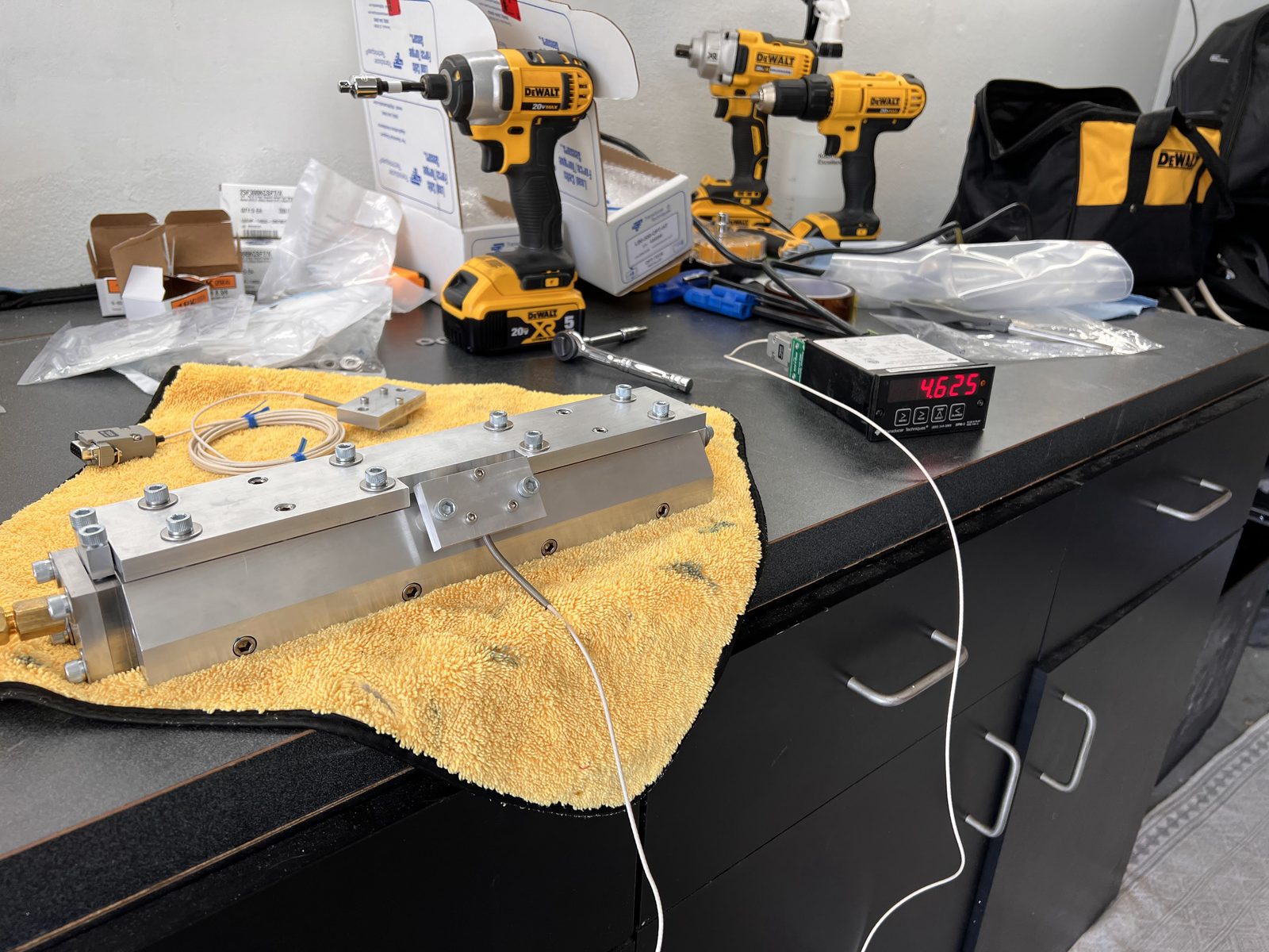 Electro-mechanical test rig on a bench with load cell and digital readout